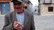Un señor mayor con gorra y chaqueta sonríe mientras sostiene un cigarro en una plaza empedrada del centro de El Toboso. Un señor mayor con gorra y chaqueta sonríe mientras sostiene un cigarro en una plaza empedrada del centro de El Toboso.