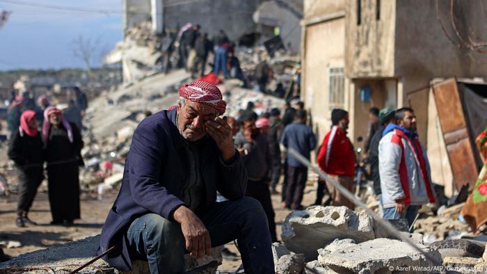 A Syrian man sits and cries on the ruins in the small town of Jindires, located in rebel-held territory