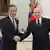 Wang Li e Vladimir Putin posam para foto apertando as mãos