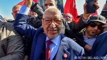 The head of Tunisia's Islamist movement Ennahdha Rached Ghannouchi greets supporters upon arrival to a police station in Tunis ,on February 21, 2023, in compliance to the summons of an investigating judge. (Photo by FETHI BELAID / AFP)