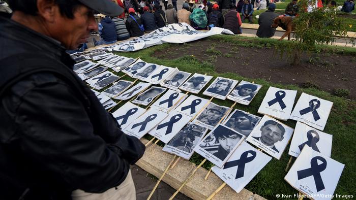 Foto de archivo de una persona que ve las imágenes de las víctimas fatales de las protestas en Perú.