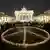 A giant peace sign is formed with candles in front of the Brandenburg Gate 