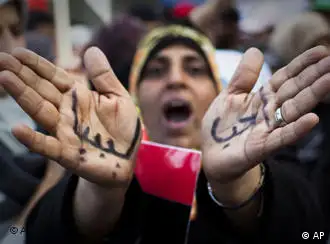 A Libyan woman reacts with her hands written on them in Arabic I love Libya' as she joins a rally in support of the allied air campaigns against the forces of Moammar Gadhafi in Benghazi, eastern Libya, Wednesday, March 23, 2011
