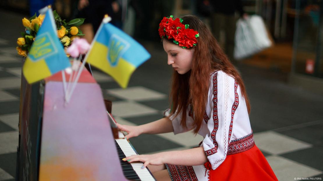 13-year old Alisa Bushuieva, who was forced to flee Ukraine at the start of the war, wears a Ukrainian national dress as she plays the piano at an event to mark the first anniversary of Russia's invasion of Ukraine in Liverpool, Britain, February 24, 2023.