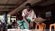 An Independent National Electoral Commission (INEC) official sets up materials at a polling station during Nigeria's presidential and general election. (Photo by Patrick Meinhardt / AFP)