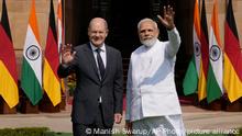 Indian Prime Minister Narendra Modi, right, with German Chancellor Olaf Scholz, wave to media before their meeting in New Delhi, India, Saturday, Feb. 25, 2023. Germany Chancellor Olaf Scholz arrived in the Indian capital on Saturday and he is expected to discuss with the Indian prime minister Russia's war in Ukraine and steps to boost bilateral cooperation in sectors such as renewables, hydrogen, mobility, pharma and digital economy, officials said. (AP Photo/Manish Swarup)