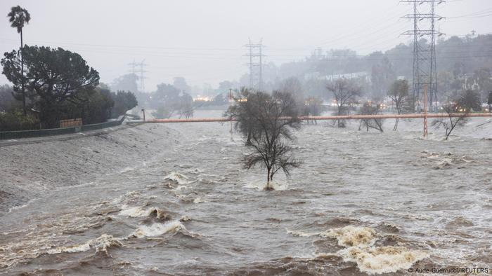 Bäume und Infrastruktur stehen in den Fluten des über die Ufer getretenen Los Angeles River Bäume und Infrastruktur stehen in den Fluten des über die Ufer getretenen Los Angeles River