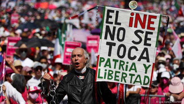 Foto de una persona que protesta en México con un rótulo que dice El INE no se toca, patria y libertad.