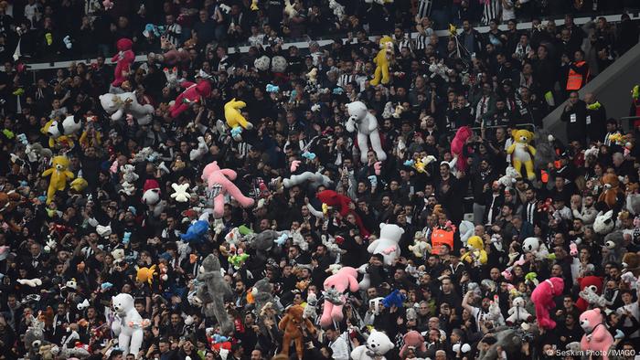 Besiktas-Fans auf der Tribüne werfen Schals, Mützen und Spielzeug auf das Spielfeld