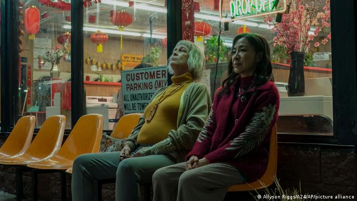 Filmszene aus Everything Everywehre All At Once zeigt zwei Frauen, die vor einem Wachssalon sitzen