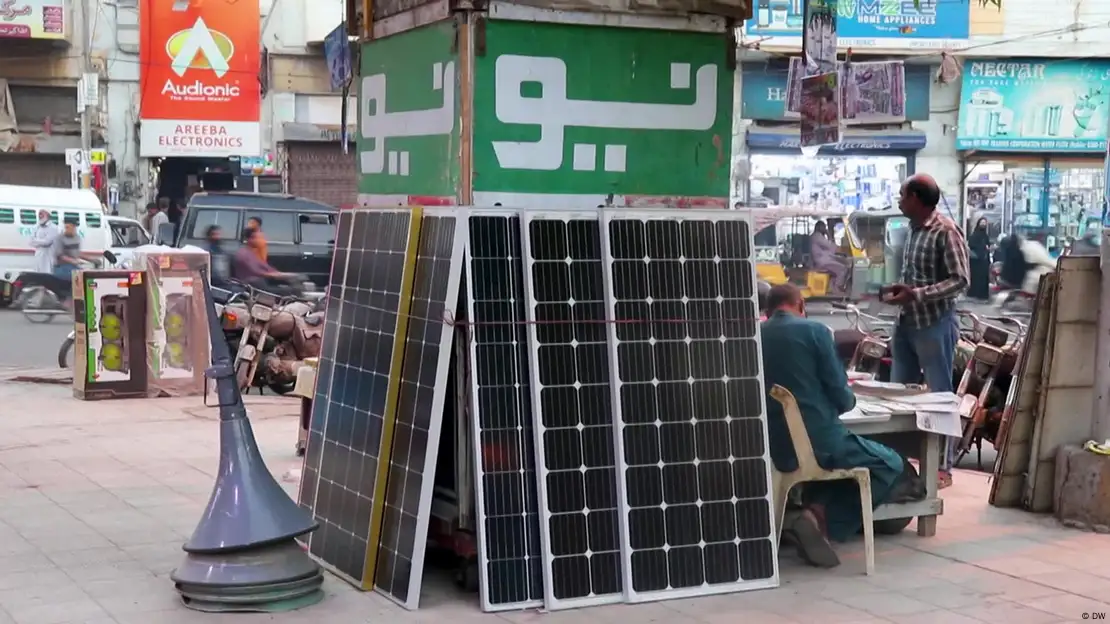 Paneles solares apoyados contra un poste en una calle de Pakistán