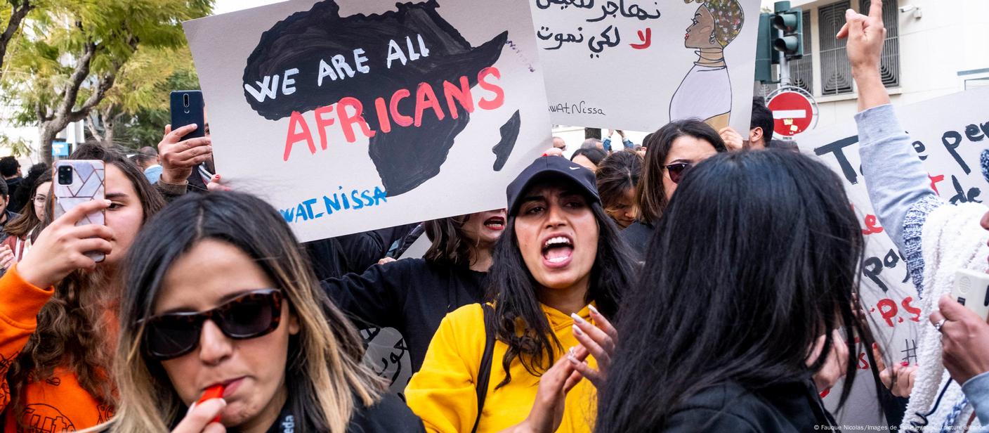 Tunisian women demonstrate against racism, holding signes reading 'We are all Africans'