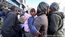27/02/2023 A child looks on while being carried by a woman as sub-Saharan African migrants wait outside the officers of the United Nations High Commissioner for Refugees (UNHCR) in Tunis on February 27, 2023, demanding a resolution of their situation. - Tunisia's president was accused on February 22 of racism and hate speech after he said hordes of sub-Saharan African migrants were causing crime and posed a demographic threat. Saied, who has seized almost total power since a dramatic July 2021 move against parliament, had urged his national security council to take urgent measures to tackle irregular migration. (Photo by FETHI BELAID / AFP)