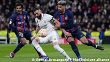 Real Madrid's Karim Benzema, centre, controls the ball as he is challenged by Barcelona's Ronald Araujo, right, and Barcelona's Jules Kounde during the Spanish Copa del Rey semi final, first leg soccer match between Real Madrid and Barcelona at Santiago Bernabeu stadium in Madrid, Spain, Thursday, March 2, 2023. (AP Photo/Bernat Armangue)