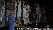 02.03.2023, Ukraine, Saporischschja: Eine Anwohnerin reagiert auf ihr beschädigtes Haus nach einem russischen Raketenangriff. Die Rakete habe in der Nacht zum 02.03.2023 ein fünfstöckiges Wohnhaus getroffen, das dann eingestürzt sei, teilte der Sekretär des Stadtrats, Kurtjew, auf seinem Telegram-Kanal mit. Foto: Kateryna Klochko/AP +++ dpa-Bildfunk +++