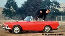 Mit einem sportlichen Sprung über die Fahrertür verläßt ein junger Mann einen roten Sunbeam Alpine 260 Tiger, der während der Frankfurter Automobilausstellung 1965 vorgestellt wird. Das sportliche Cabriolet verfügt über einen 4267 ccm Hubraum, 141 PS und eine Spitzengeschwindigkeit von 190 Stundenkilometern. Sein Preis beträgt rund 17 000 Mark. [dpabilderarchiv]