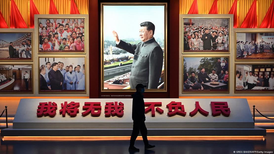 A man walks past a photo of Chinese President Xi Jinping at the Museum of the Communist Party of China in Beijing