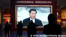 People walk past a video screen showing a speech by Chinese President Xi Jinping at the Museum of the Communist Party of China in Beijing on March 3, 2023, ahead of the opening of the annual session of the National Peoples Congress on March 5. (Photo by GREG BAKER / AFP) (Photo by GREG BAKER/AFP via Getty Images)