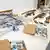 Confiscated firearms, some wrapped in plastic, and ammunition lie on tables
