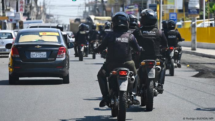 Policías en moto en una calle, autos circulan alrededor.