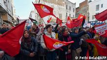 Demonstrators lift placards and national flags during an anti-government rally called for by the powerful trades union federation UGTT in Tunis, on March 4, 2023. (Photo by FETHI BELAID / AFP)