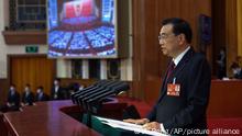 In this photo released by Xinhua News Agency, Chinese Premier Li Keqiang delivers a government work reports during the opening session of China's National People's Congress (NPC) at the Great Hall of the People in Beijing, Sunday, March 5, 2023. (Ju Peng/Xinhua via AP)