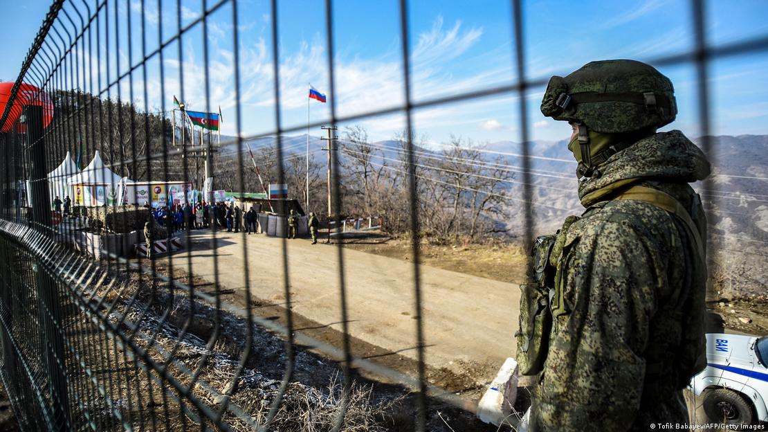 A Russian peacekeeper stands next to a fence