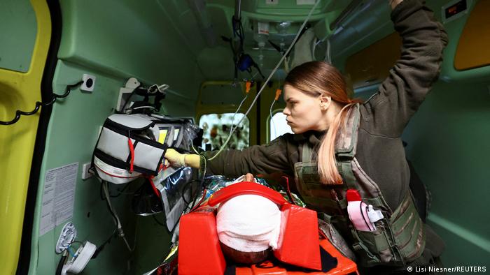 Se ve la cabeza vendada del herido tumbado en la camilla dentro de una ambulancia mientras la paremédico Marjana, del Primer Hospital Móvil de Voluntarios Pirogov, comprueba sus constantes vitales.