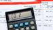 Calculadora com "CO₂" indicado na tela, repousada sobre extratos bancários.
