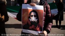 04.03.2023**March 4, 2023, Madrid, Spain: A woman holds a placard with a drawing of a girl wearing gas masks in Iran during the demonstration. Iranian citizens residing in Spain, protest in Plaza de Cibeles, Madrid, against the hundreds of cases of girls poisoned in schools that have been reported since last November in Iran. (Credit Image: © Diego Radames/SOPA Images via ZUMA Press Wire