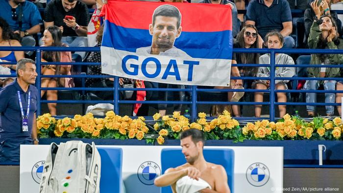 Novak Djokovic wischt sich den Schweiß von seinem Oberkörper Novak Djokovic wischt sich den Schweiß von seinem Oberkörper
