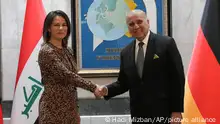 Iraqi Foreign Minister Fouad Hussein, right, shakes hands with his German counterpart Annalena Baerbock at the Ministry of Foreign Affairs in Baghdad, Iraq, Tuesday, March 7, 2023. (AP Photo/Hadi Mizban)