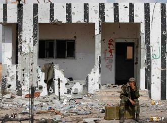 A Libyan rebel fighter sits near to the western gate of Ajdabiya, Libya, Friday, April 1, 2011