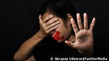 Woman wrapping mouth with tape and show hand sign stop abusing violence