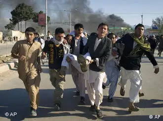 Afghans carrying a man, who got wounded following an attack on UN's office during a demonstration to condemn the burning of a copy of the Muslim holy book by a Florida pastor, in Mazar-i- Sharif north of Kabul, Afghanistan on Friday, April. 1, 2011. An Afghan official says seven people have been killed at a U.N. office in the northern city of Mazar-i-Sharif when a Quran burning protest turned violent. (AP Photo/Mustafa Najafizada)