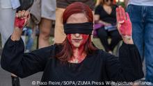 October 4, 2022**, Barcelona, Spain: A protester blindfolded as she makes the warning signal for gender violence. A hundred people have gathered in Plaza de Catalunya in solidarity with the women who suffer the repression of the Islamic dictatorship in Iran after the murder of Masha Amini at the hands of the ''moral police'' for not wearing the mandatory veil correctly. (Credit Image: © Paco Freire/SOPA Images via ZUMA Press Wire