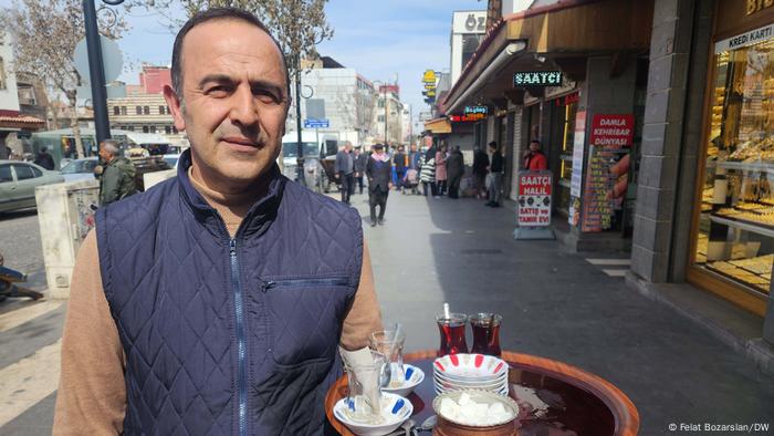 Nizam Özbek steht mit einem Tablett voller Teegläser vor seiner Cafeteria in Diyarbakir 
