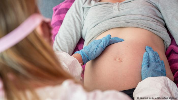 Una comadrona en la revisión médica con una embarazada.