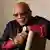Quincy Jones sitzt lächelnd auf einem Stuhl 