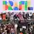 En un colorido cartel al fondo se lee "Brasil" y diversas políticas acompañan sentadas en el estrado a Lula da Silva.