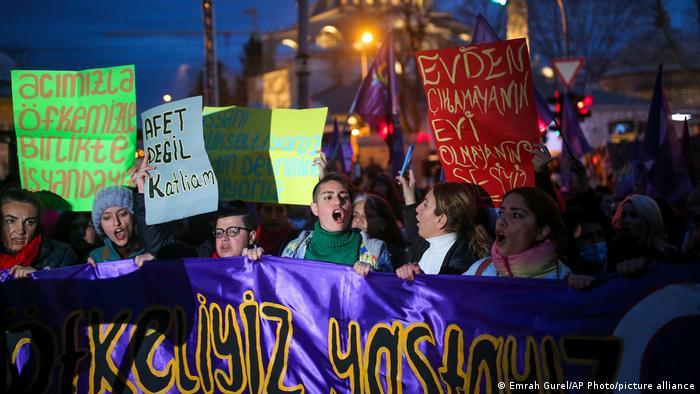 Protestierende auf einer Demonstration zum Internationalen Frauentag halten Transparente in die Höhe und skandieren