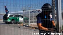 A police officer guards a gate at the Arturo Merino Benitez International Airport in Santiago on March 8, 2023, after the failed robbery of more than 32 million US dollars from an armoured van which had just picked the money from a Latam Airline plane arriving from Miami. - An officer of the General Direction of Civil Aviation and one of the attackers were killed in a shootout. (Photo by Karin POZO / AFP) (Photo by KARIN POZO/AFP via Getty Images)