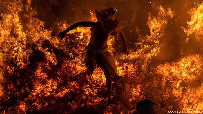 Un sacerdote hindú salta de una gran hoguera para representar la quema del demonio Holika en un ritual de Holi, en Phaelen, India. Según la tradición, aquí se desarrolló la historia mitológica de Prahlad, hijo del rey demonio Hiranyakashyapu, y Holika. Prahlad había desafiado a su padre e insistió en adorar a Vishnu. Su padre ordenó a Holika, la tía del niño, que lo quemara en una pira.