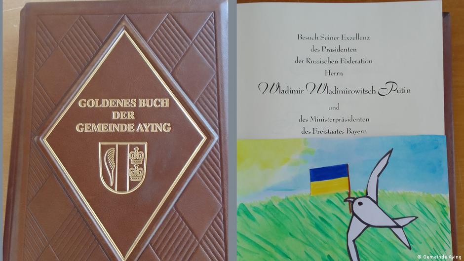 Potpis Vladimira Putina u Zlatnoj knjizi grada Ajinga prekriven je slikom ukrajinskog deteta