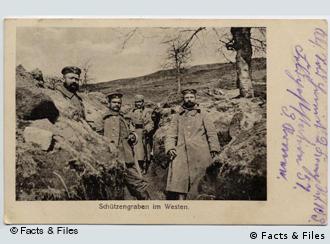 A black and white photo postcard of soldiers in a field