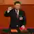 Presidente chinês, Xi Jinping, presta juramento com o punho direito erguido e a outra mão sobre a Constituição da China