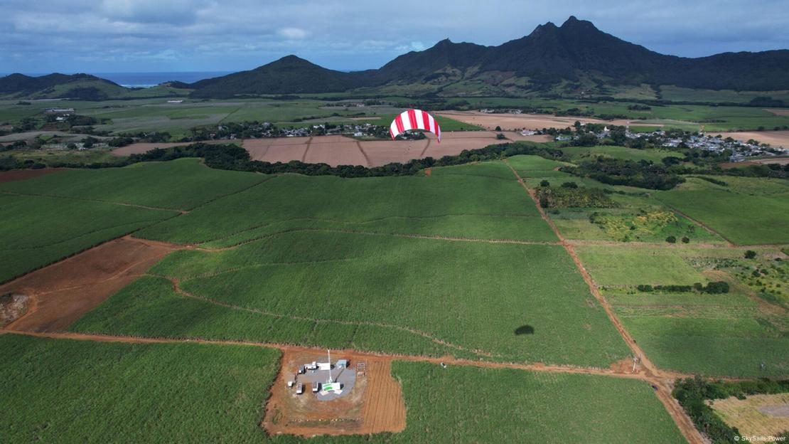 A prototype of a SkySails turbine kite flying above a green field