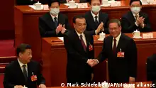 Chinese President Xi Jinping, at left, looks on as newly elected Chinese Premier Li Qiang at right shakes hands with former Premier Li Keqiang during a session of China's National People's Congress (NPC) at the Great Hall of the People in Beijing, Saturday, March 11, 2023. (AP Photo/Mark Schiefelbein)