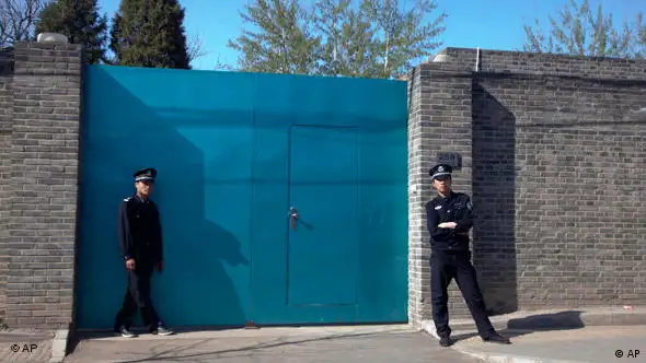 A Chinese police officer, right, and a security guard stand outside the entrance to Ai Weiwei's studio in Beijing Sunday, April 3, 2011. China blocked Ai Weiwei, one of its most famous contemporary artists, from taking a flight to Hong Kong on Sunday and police later raided his Beijing studio, the man's assistant said. (AP Photo/Ng Han Guan)