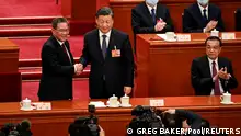 11.03.2023**China's President Xi Jinping (C) shakes hands with newly-elected Premier Li Qiang (L) as former Premier Li Keqiang (R) applauds during the fourth plenary session of the National People's Congress (NPC) at the Great Hall of the People in Beijing, China on March 11, 2023. GREG BAKER/Pool via REUTERS